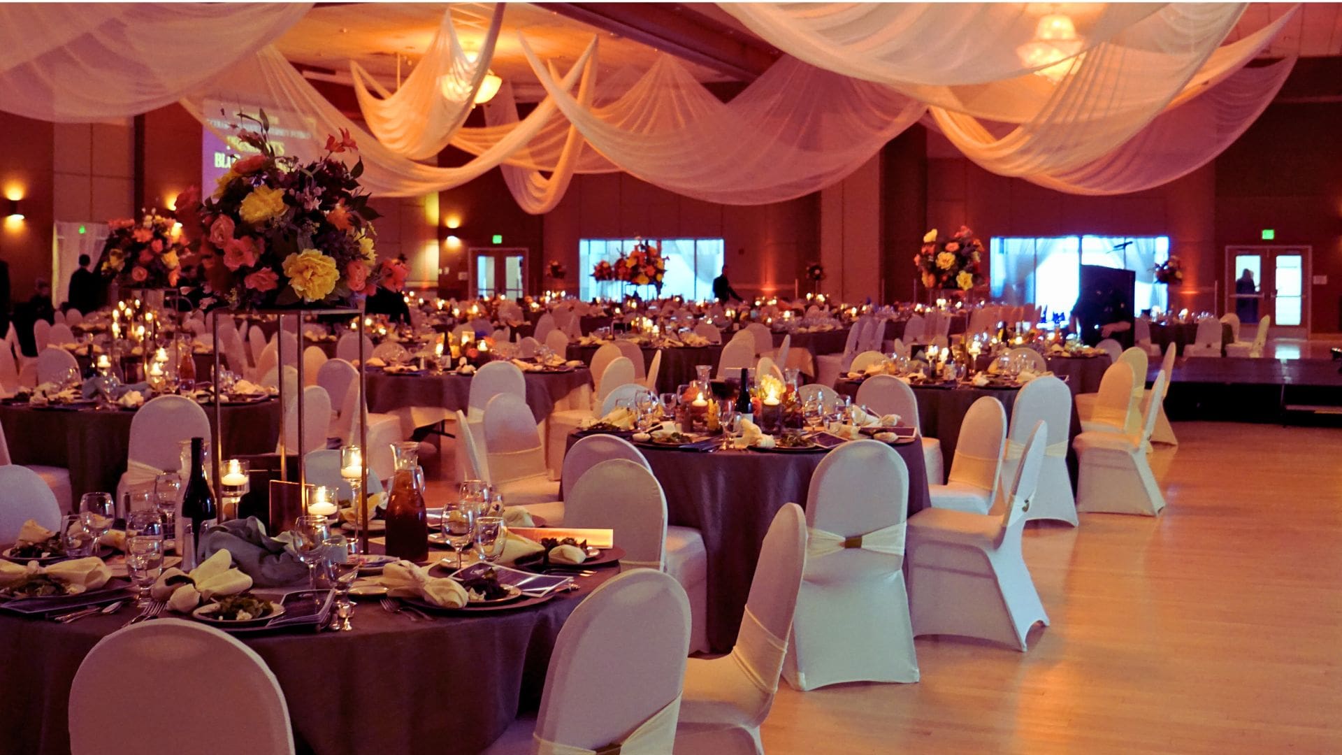 decorated room with tables chairs set up for catering